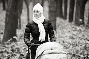 yang et belle mère avec poussette de bébé en plein air. photo