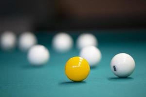 boules de billard blanches et jaunes sur fond vert. photo