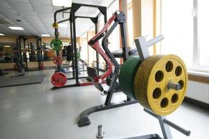 entraîneur sportif avec des poids métalliques pour la barre dans la salle de gym. photo