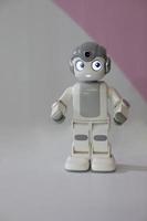 figurine d'un petit robot sur fond gris. photo