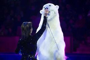 un dresseur d'animaux avec un ours polaire se produit au cirque. ours de cirque. photo