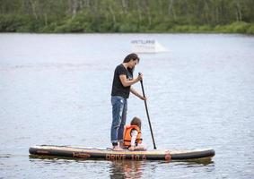 kamchatka, russie - 10 juin 2021 - hommes et femmes avec son bébé stand up paddle photo