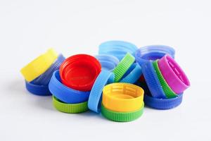 bouchons de bouteilles en plastique colorés pour recyclage sur fond blanc. photo