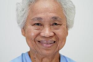 aînée asiatique femme âgée patiente assise et visage souriant avec plaisir sur le lit à l'hôpital. photo