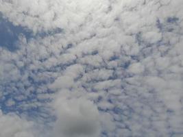 beaux nuages blancs sur fond de ciel bleu profond. de grands nuages doux et moelleux couvrent tout le ciel bleu. photo