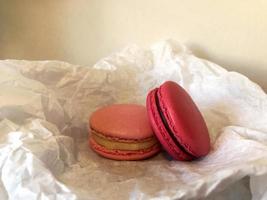 deux macarons de gâteau rose se trouvent sur du papier blanc, vue horizontale en gros plan de dessert sucré, photo d'accueil