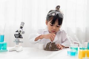 concept d'éducation, de science, de chimie et d'enfants - enfants ou étudiants avec expérience de fabrication de tubes à essai au laboratoire de l'école photo