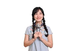 portrait de la belle jeune femme asiatique sourire en robe denim avec cuillère et fourchette sur fond blanc photo