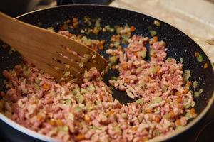 Femme faisant cuire la sauce bolognaise dans la cuisine photo