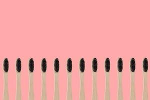brosses à dents en bambou écologiques sur fond rose photo