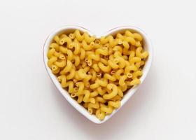 cavatappi de pâtes crues dans un bol de coeur. photo