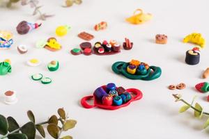 roule sur un plateau et autres aliments en argile polymère sur fond clair. loisirs des enfants. photo