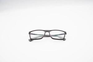 lunettes noires à monture épaisse photographiées sur fond blanc, lors d'une séance photo en janvier 2023