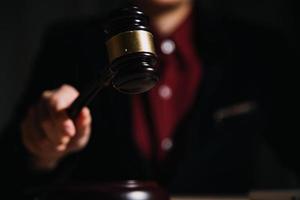 concept de justice et de droit. juge masculin dans une salle d'audience avec le marteau, travaillant avec, clavier d'ordinateur et d'accueil, lunettes, sur table à la lumière du matin photo