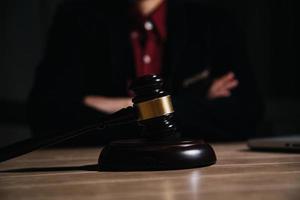 concept de justice et de droit. juge masculin dans une salle d'audience avec le marteau, travaillant avec, clavier d'ordinateur et d'accueil, lunettes, sur table à la lumière du matin photo