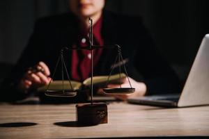 concept de justice et de droit. juge masculin dans une salle d'audience avec le marteau, travaillant avec, clavier d'ordinateur et d'accueil, lunettes, sur table à la lumière du matin photo