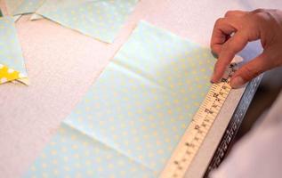mains féminines de designer au travail avec gros plan de tissu. tailleur mesurant la quantité nécessaire de matériel pour coudre le tissu. photo