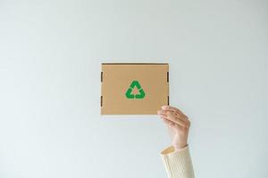 femme portant le concept de boîte à papier de réutilisation, recyclage d'objets à zéro déchet. concept de durabilité utilisant une boîte en carton de papier recyclé pour sauver le réchauffement climatique. photo