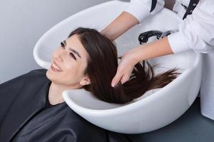 coiffeur professionnel laver les cheveux de la jeune femme dans un salon de beauté. gros plan des cheveux de la femme dans un salon de beauté, concept de coiffure photo