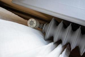 ancien radiateur avec thermostat et possibilité de réduire la température de chauffage. concept d'augmentation des coûts de chauffage. vue de dessus. photo