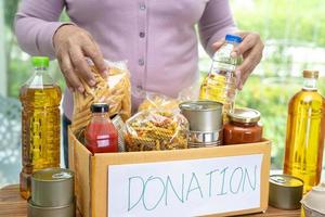 denrées alimentaires pour le don, le stockage et la livraison. divers aliments, pâtes, huile de cuisson et aliments en conserve dans une boîte en carton. photo