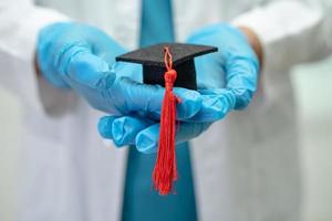 étude de médecin asiatique apprendre avec un chapeau d'écart de graduation dans la salle d'hôpital, concept de médecine d'éducation de génie brillant intelligent. photo