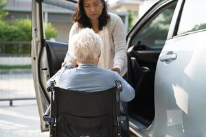 Une patiente asiatique âgée ou âgée, assise sur un fauteuil roulant, se prépare à aller à sa voiture, concept médical solide et sain. photo