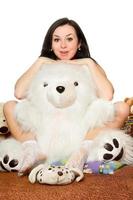 fille assise dans une étreinte avec un gros ours en peluche photo