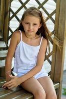 fille assise sur un banc en bois photo