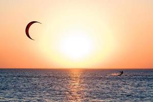 kitesurfeur sur un golfe au coucher du soleil photo