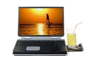 ordinateur portable et cocktail. isolé sur fond blanc photo