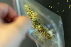 paquet de bourgeons et de mains de cannabis à fermeture à glissière ouverte photo