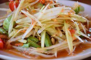 salade de papaye ou somtom en thaï, sur plat blanc. photo