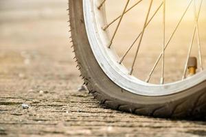 vue rapprochée d'une roue à plat de vélo ou d'un pneu à plat de vélo qui s'est garé près de la route et en attente de réparation. photo