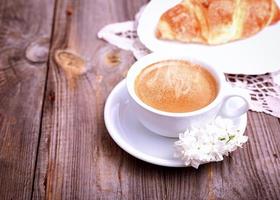 tasse de café et croissant sur fond de bois gris photo