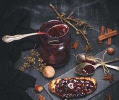 confiture de framboises dans un bocal en verre avec une cuillère en fer photo