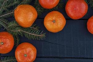 branche mangée avec des mandarines mûres sur une surface en bois noire, vue de dessus, un espace vide photo