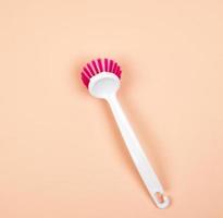 brosse de cuisine avec manche en plastique blanc sur fond beige photo