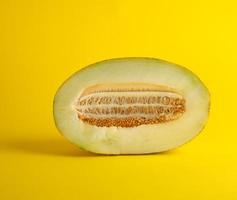 morceau de melon mûr avec graines sur fond jaune photo
