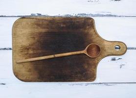 vieille planche à découper de cuisine brune et cuillère en bois photo