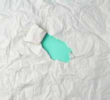 feuille de papier froissée grise avec un trou, support vert photo