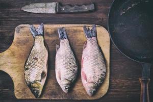 poisson carpe sur une planche à découper de cuisine photo