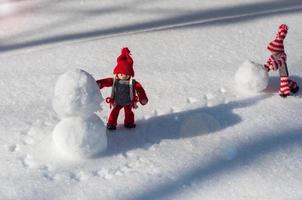 deux jouet petit homme a roulé une boule de neige photo