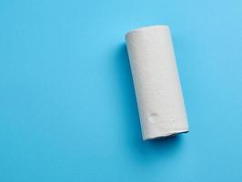 rouleau torsadé de serviette en papier blanc sur fond bleu photo