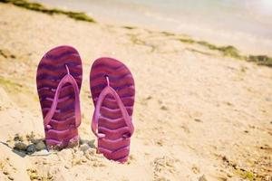 chaussons de plage violets sur la plage photo