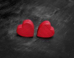deux coeurs en bois rouge sur fond noir photo