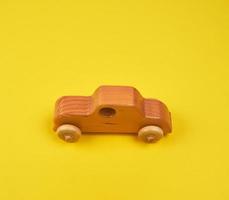 voiture pour enfants en bois sur fond jaune photo