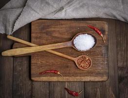 cuillère en bois avec gros sel blanc et épices photo