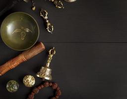 bol chantant en cuivre, chapelet, tambour de prière, boules de pierre et autres objets religieux tibétains photo