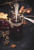 confiture de framboises dans un bocal en verre avec une cuillère en fer photo